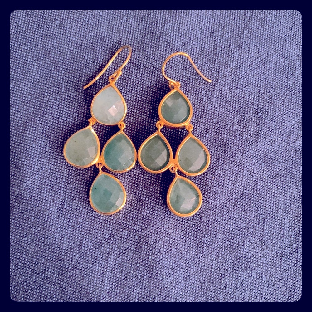 Gold statement earrings with green stones.